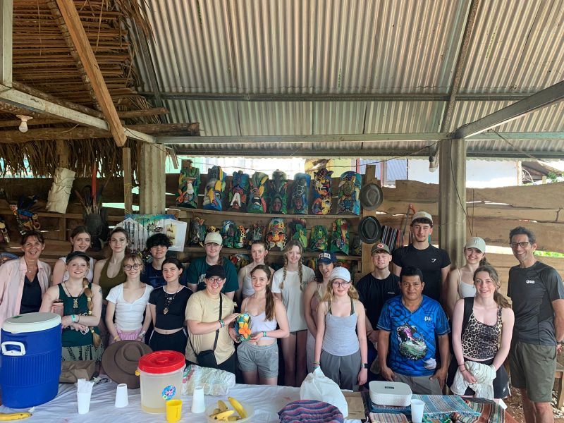 Group of young tourists visit a Costa Rican indigenous craft stall