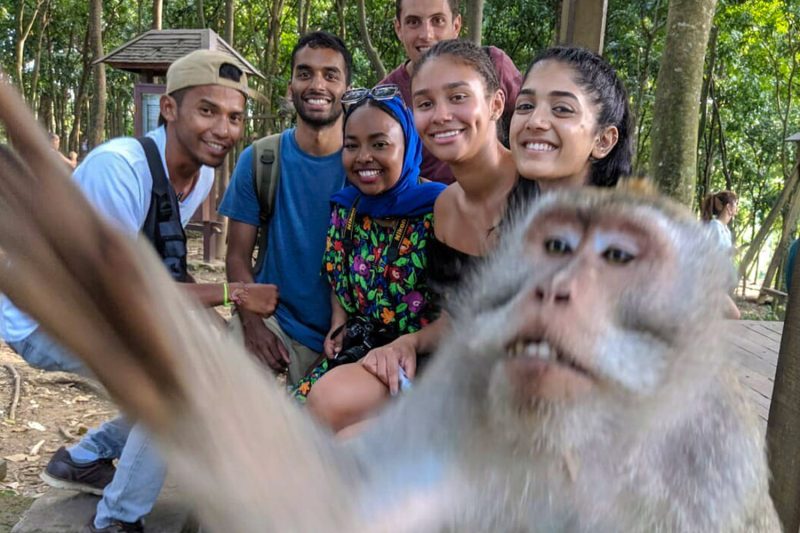 Group of people having photo taken with monkey